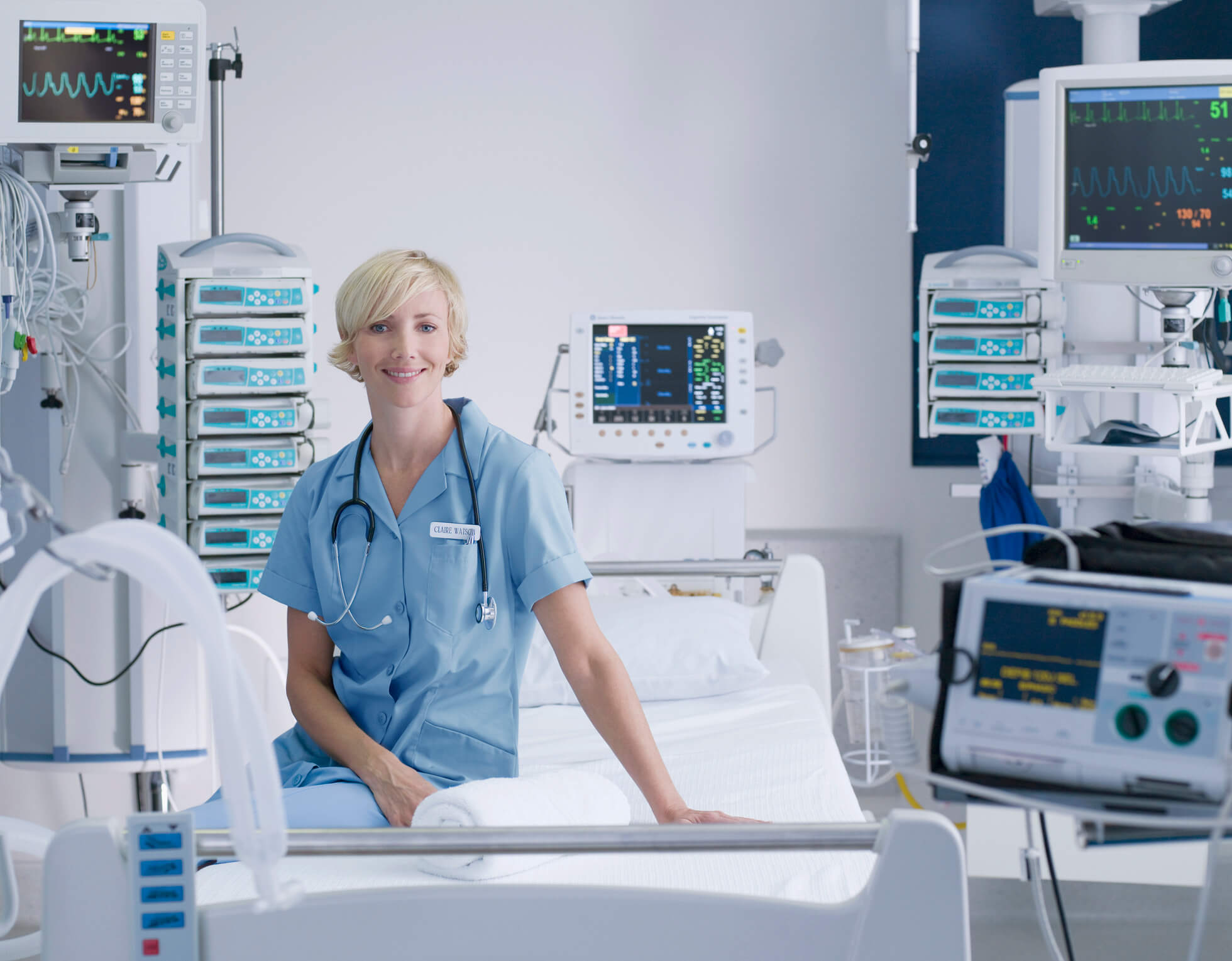 nurse sitting on hospital bed surrounded by equipment