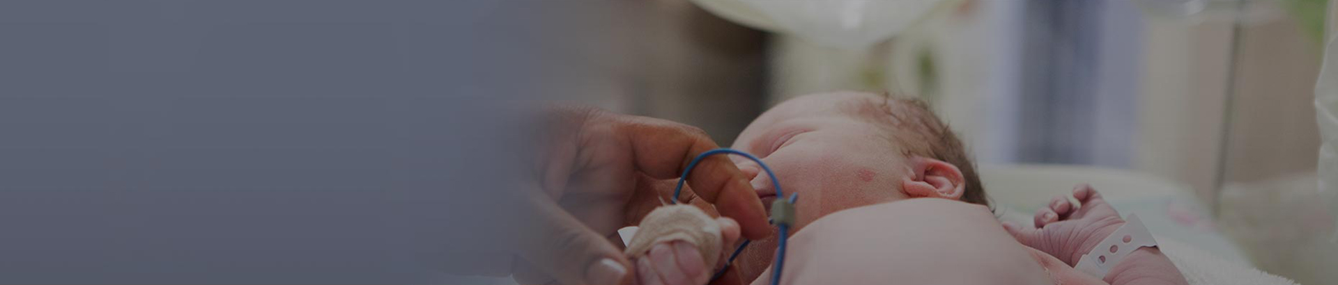 Adult hand holding newborn baby's hand